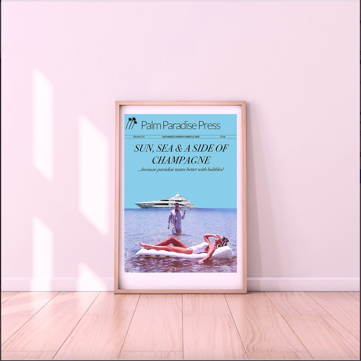A framed art print leaning against a light pink wall on a wooden floor. The print features a light blue background with the text 'Palm Paradise Press' and 'SUN, SEA & A SIDE OF CHAMPAGNE', above an illustration of a woman floating on a lilo in the water with a yacht in the distance.