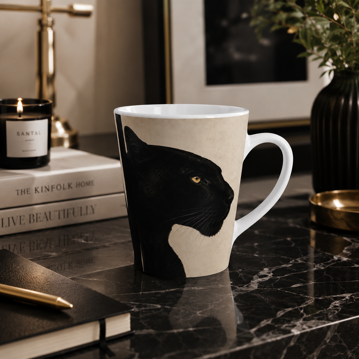 A ceramic mug featuring a black panther profile illustration on a cream background, set on a dark marble tabletop with books, a candle, and framed art in a styled interior.