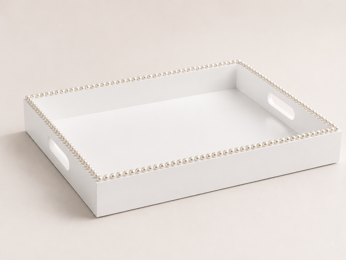 A white rectangular serving tray with two cutout handles and a decorative border of small pearl-like beads, shown on a light beige background.