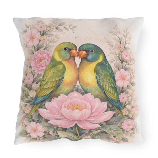 Square decorative throw pillow featuring a vintage-style illustration of two green and yellow lovebirds facing each other, surrounded by pink flowers on a light beige background.