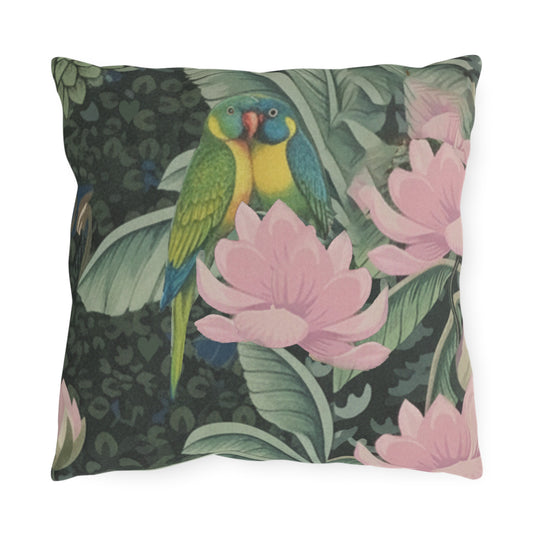 A square throw pillow featuring a detailed illustration of two green and blue parrots among pink lotus flowers and tropical leaves on a dark background.